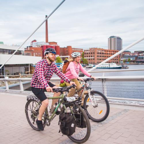 Pyöräilijät Laukontorin sillalla, taustalla ravintola Kuuma.