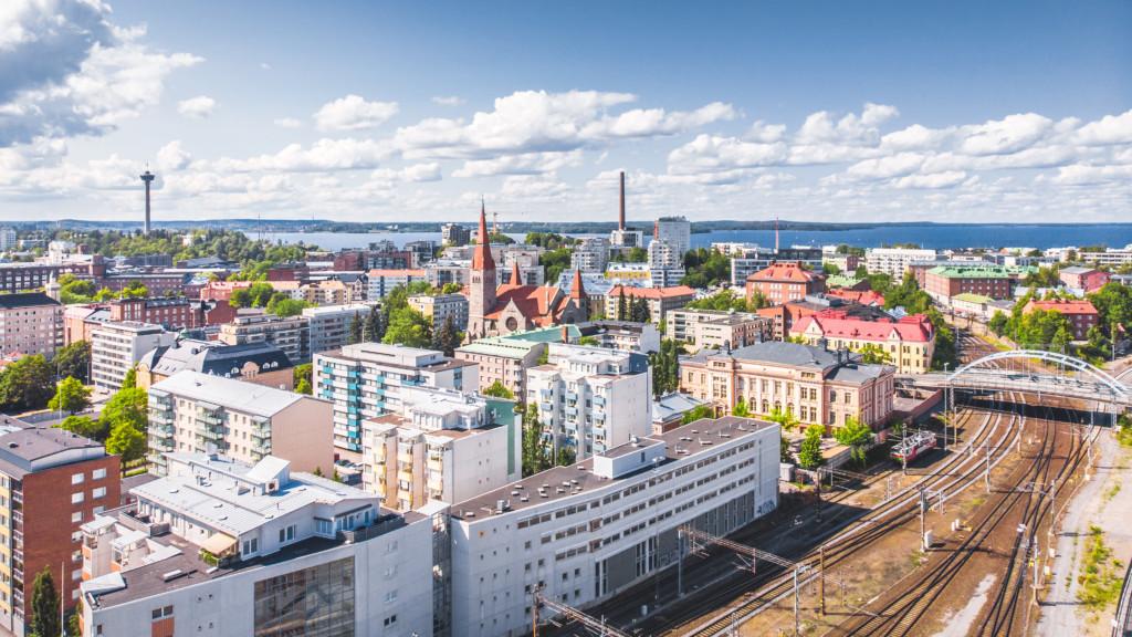 Näkymä Tampereen rakennuksista ja junaradasta ylhäältä dronella kuvattuna.